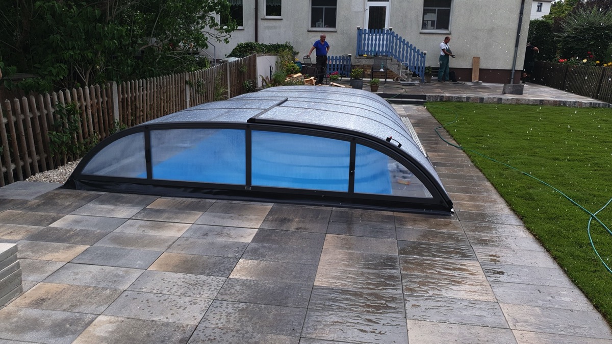 Aufgeschobene Pool-Überdachung über einem Fertigbecken