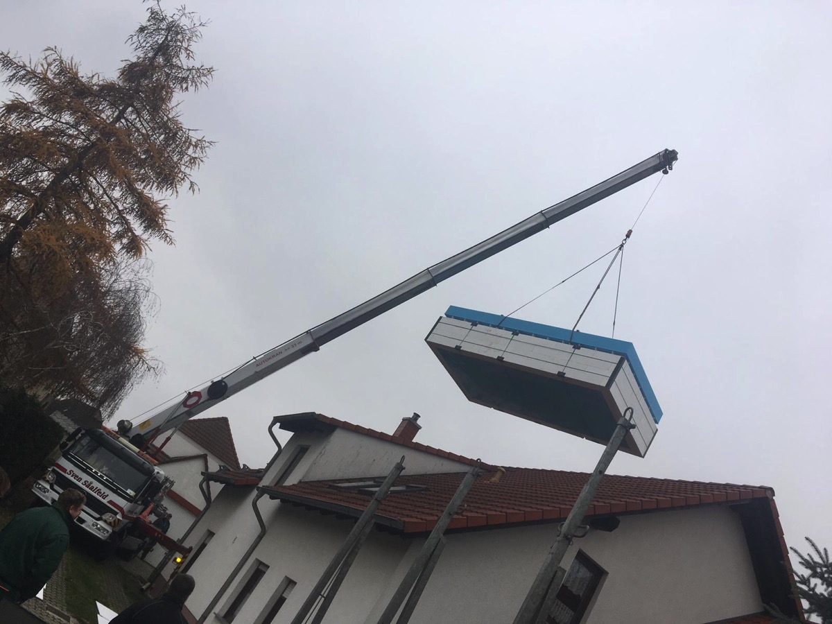 Pool wird mit einem Kran in den Garten gehoben